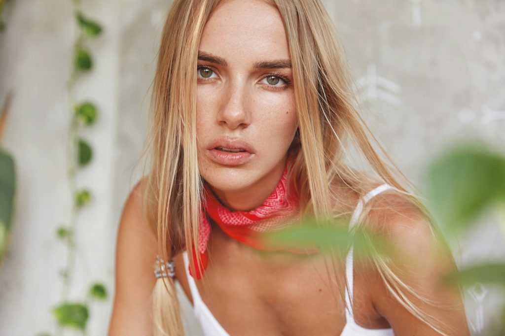 Portrait of pleasant looking female model with healthy pure skin, dressed casually, going to ride bi