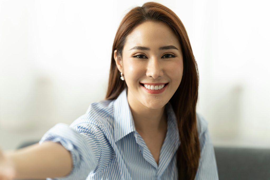 Young asian woman taking selfie. webcam and video conference concept.